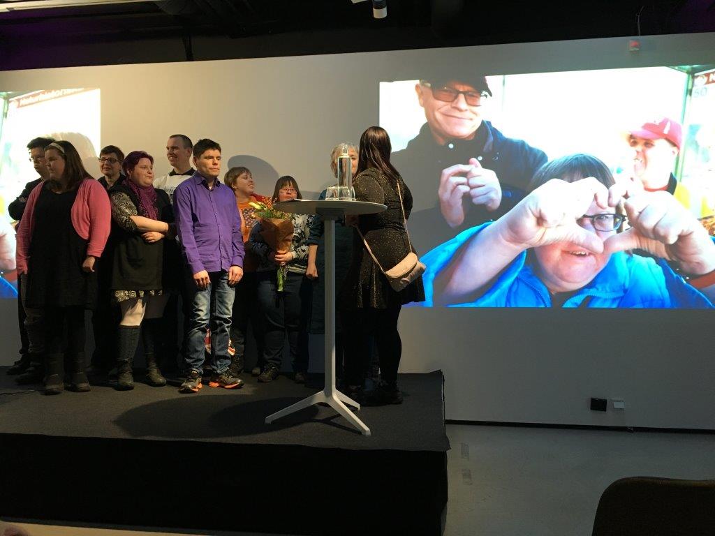 Anpassad IT vann Arvsfondens guldkorn 2018. Deltagarna på scen medan en film visas om projektet.